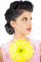 Thoughtful black hair model holding a flower and looking away