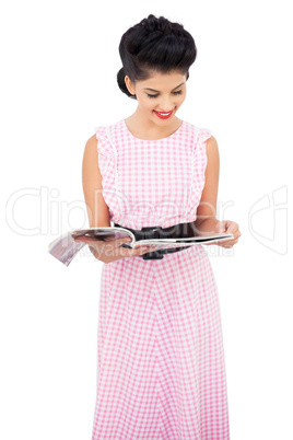 Pleased black hair model reading a magazine