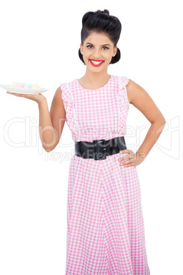 Joyful black hair model holding a plate of candies