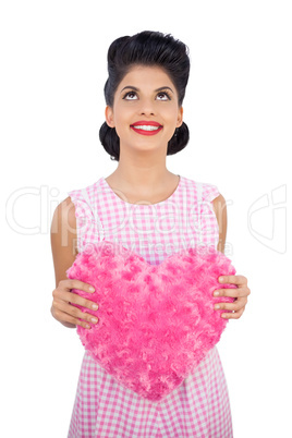 Content black hair model holding a pink heart shaped pillow
