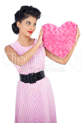 Stylish black hair model holding a pink heart shaped pillow
