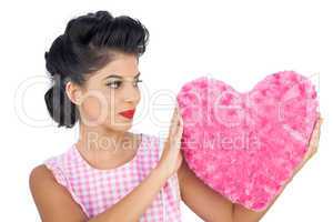 Charming black hair model holding a pink heart shaped pillow