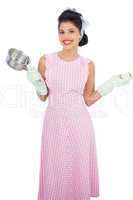 Joyful black hair model holding a pan and wearing rubber gloves