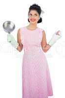 Cheerful black hair model holding a pan and wearing rubber glove