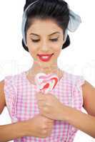 Content black hair model holding a heart shaped lollipop
