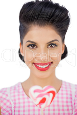 Happy black hair model holding a heart shaped lollipop