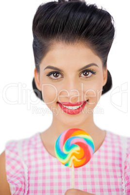 Joyful black hair model holding a colored lollipop