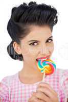 Attractive black hair model chewing a colored lollipop