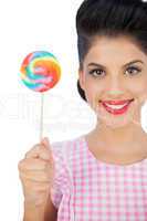 Pleased black hair model holding a colored lollipop