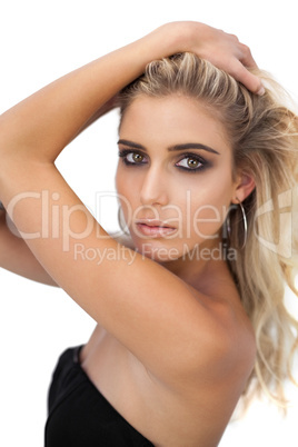 Pretty blonde model in black dress posing hands in the hair