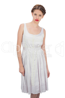 Serious model in white dress posing looking at camera