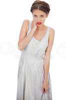 Embarrassed model in white dress posing hand on the neck