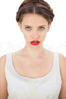 Concentrated model in white dress posing looking at camera