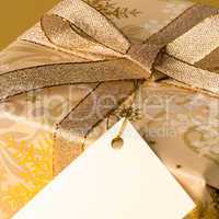 Gold Christmas present with blank tag wishing card