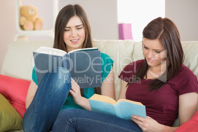 Two girls reading books on the couch