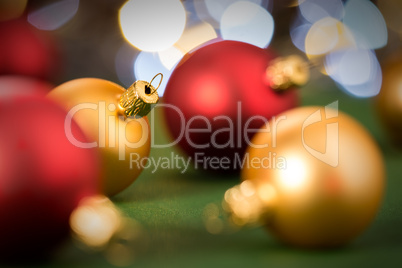 Gold and red christmas baubles on green