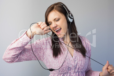 Smiling young brunette listening to music