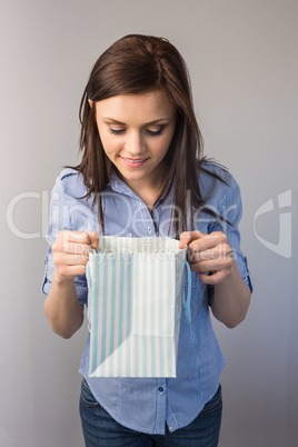 Smiling pretty brunette receiving a present