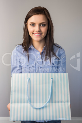 Cheerful pretty brunette offering a present