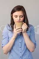 Young pretty brunette smelling coffee