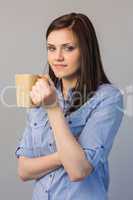 Smiling pretty brunette holding cup of coffee