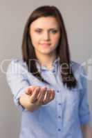 Smiling pretty brunette presenting her empty hand