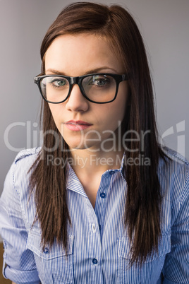 Serious pretty brunette wearing glasses posing