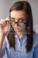 Serious brunette holding glasses posing