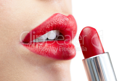 Extreme close up on model applying red lipstick