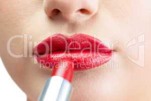 Extreme close up on beautiful red lips being made up