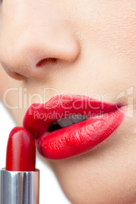 Extreme close up on gorgeous red lips being made up