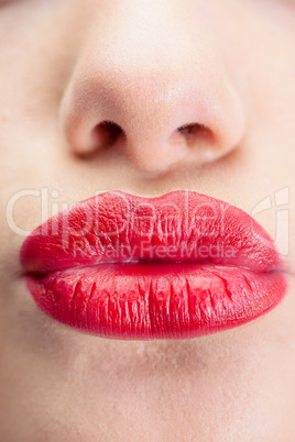 Extreme close up on gorgeous red lips kissing at camera