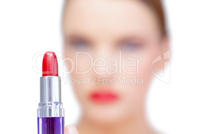 Nude blonde model holding red lipstick