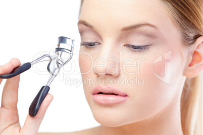 Sensual blonde model using eyelash curler