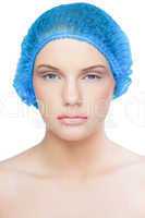 Unsmiling pretty model wearing blue surgical cap