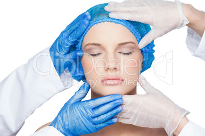 Surgeons examining content young blonde wearing blue surgical ca