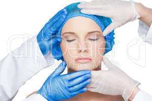 Surgeons examining content young blonde wearing blue surgical ca