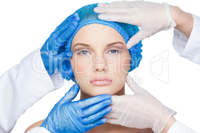 Surgeons examining content blonde wearing blue surgical cap