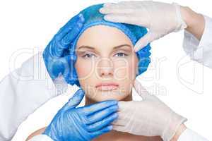 Surgeons examining content blonde wearing blue surgical cap