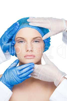 Surgeons examining relaxed blonde wearing blue surgical cap