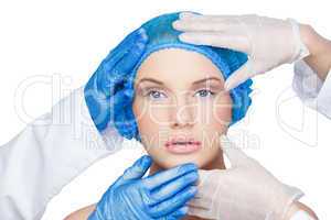 Surgeons examining calm blonde wearing blue surgical cap