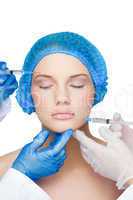 Surgeons making injection on peaceful blonde wearing blue surgic