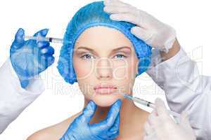 Surgeons making injection on pretty blonde wearing blue surgical