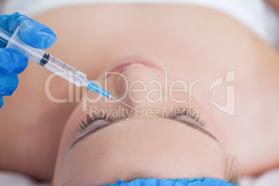 Surgeon making injection on pretty woman lying
