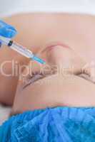 Surgeon making injection on cute woman lying