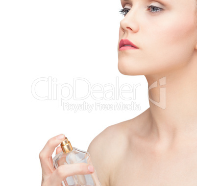 Beautiful nude model spraying perfume