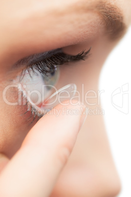 Extreme close up on pretty model applying contact lens