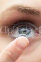 Extreme close up on cute model applying contact lens