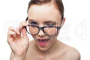 Cheerful model winking at camera over her classy glasses