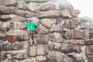 Determined man scaling a large rock face